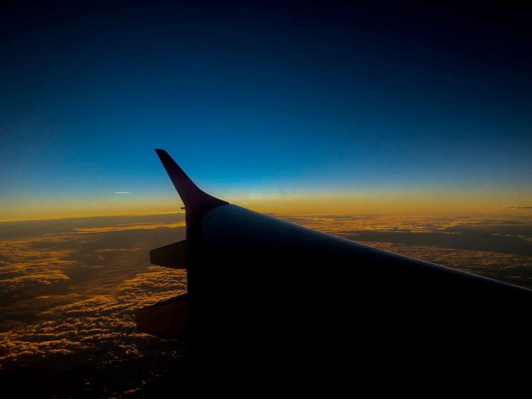 Traveler standing beside a small airplane